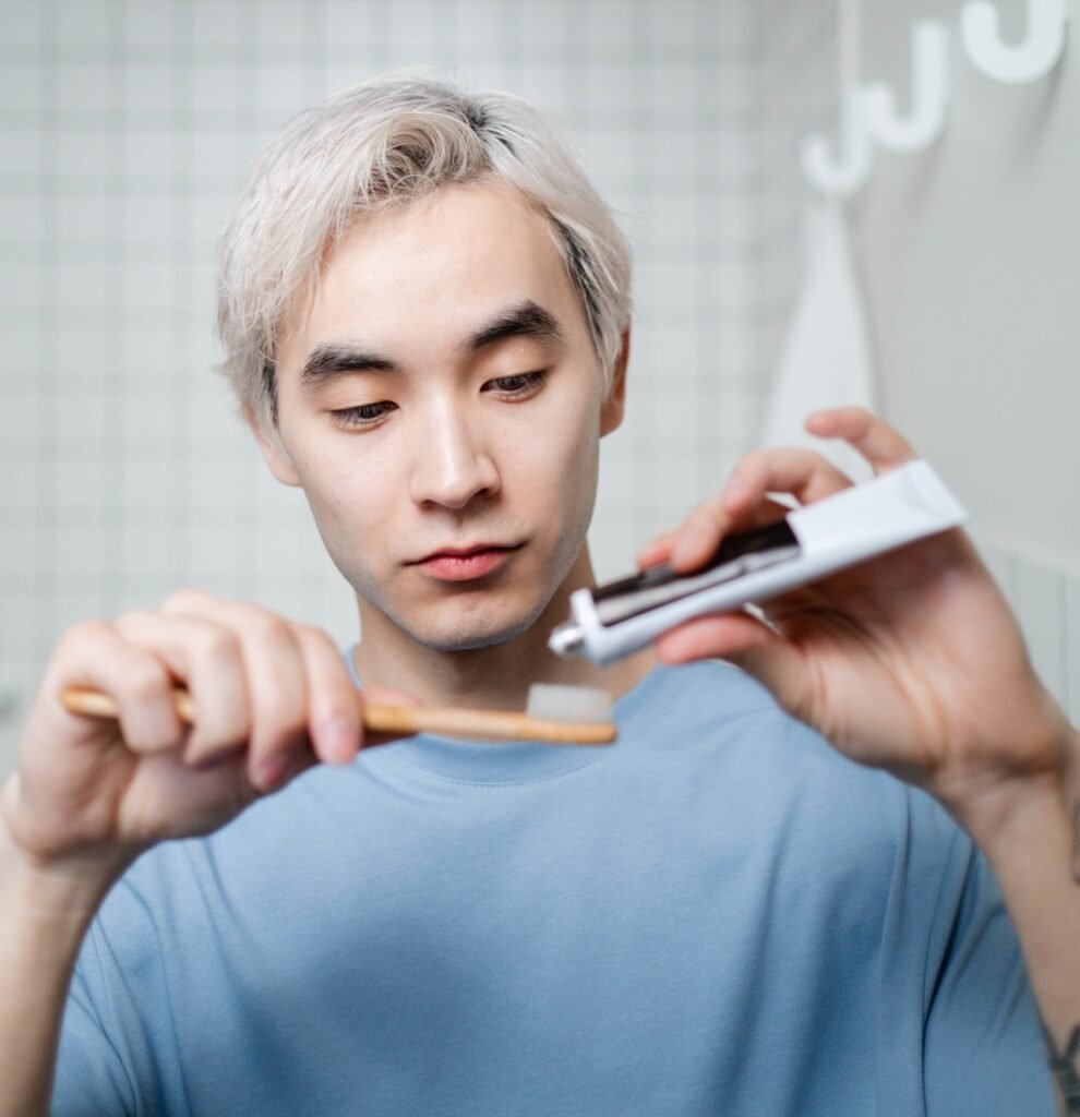 person putting toothpaste on brush