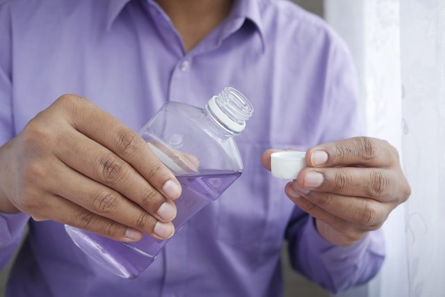 person pouring mouthwash