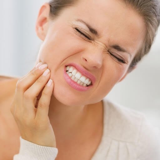 person in pain holding jaw